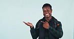 Male, student and pointing in studio on blue background in mockup of presentation for product placement. African, person or man with smile, excitement or happy in graduation, announcement or support 