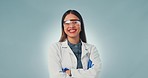 Science woman, face and smile with arms crossed in studio, pride and happy by blue background. Doctor, research expert and excited for medical innovation with ppe glasses, gloves and healthcare job