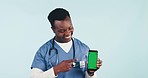 Nurse, happy man with phone and green screen in studio for telehealth, online healthcare and expert advice. Medical professional, caregiver or doctor with digital app for health on blue background