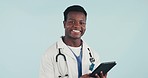 Doctor, man and tablet with smile, studio or face for telehealth, data analysis or review by blue background. African medic, nurse and digital touchscreen for scroll, typing or pride at hospital job