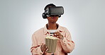 Popcorn, virtual reality and headset to watch a movie in metaverse, 3d world and ai. Black person eating snack and streaming digital glasses on studio white background with future cinema technology