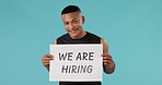 Hiring, fitness and man personal trainer with poster for job opportunity isolated in a studio blue background. Gym, health and portrait of coach showing recruitment sign or board for health club