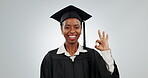 Woman, graduation and ok sign of student in studio for school achievement and education success. Face of happy black person graduate with okay hand emoji for college scholarship on a white background