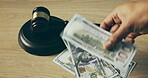 Judge gavel, money and hand for bribe on table or auction, corruption and court expense. Dollar bill, finance and mallet for laundering, currency or law attorney for fraud, debt or government scam