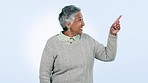 Choice, presentation and senior woman with hand pointing in studio for solution, step or guide on blue background. Decision, review and elderly lady model show application, sign up or vote checklist