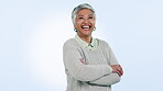 Happy, senior woman and arms crossed in portrait with confidence, pride and success on blue background. Studio, face and elderly lady smile with natural beauty, wellness and happiness in retirement