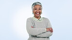 Happy, senior woman and arms crossed in portrait with confidence, pride and success on blue background. Studio, face and elderly lady smile with natural beauty, wellness and happiness in retirement