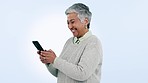 Senior woman, phone and laugh in studio for contact, texting and funny meme on web by blue background. Mature lady, smartphone and reading on social media app, comic video or excited for notification