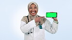 Healthcare, phone and green screen with a muslim woman doctor in studio on blue background for social media. Portrait, medical or smile and medicine professional showing mockup with tracking markers