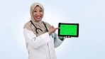 Doctor, woman and tablet green screen or presentation, speaking of healthcare information and advice in studio. Face of muslim person in medical or digital mockup, tracking marker and blue background