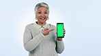 Phone, green screen and senior woman with presentation, mockup and pointing to app, tracking markers or menu. Easy, steps and person with promotion of tech, information and hands gesture to cellphone