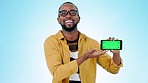 Black man, pointing and phone green screen in advertising or marketing against a studio background. Portrait of happy African male person smile showing mobile smartphone app, display or mockup space