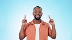 Man, pointing up and promotion in studio, smile and face with announcement by blue background. Happy African guy,  direction and hands in air for deal, sales and presentation with sign in portrait