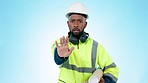 Construction worker, face and man with stop hand pointing in studio for with no, safety or warning on blue background. Building, fail and portrait of engineer show wrong emoji for industry feedback