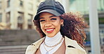 Face, fashion and wind with a happy black woman on the street for urban style, cosmetics or clothing. Portrait, smile and a young model in the city for luxury makeup or beauty on a summer morning