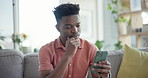 Black man, smartphone and reading online with social media, relax on sofa at home with technology and internet. Connection, text message or email with contact, chat and search website or blog 