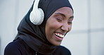 Woman, smile and headphones for streaming radio, funny and hearing a joke on break from run. Happy muslim person, freedom and listening to audio, podcast and sound with modest sportswear or hijab