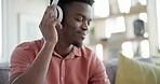 Black man, headphones and listening to music, dancing to techno sound with wireless technology at home. Relax with audio streaming, wellness and energy, fun in lounge with subscription and radio