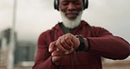 Senior runner man, smart watch and headphones in city, street and time for fitness, health or wellness in retirement. African guy, iot clock and training to check progress, music or road in Cape Town