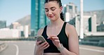 Phone, fitness and woman typing in the city for race, marathon or competition training. Technology, smile and young female athlete runner scroll on social media with cellphone for sports in town.