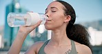 City, fitness and woman drinking water, tired and exercise with wellness, workout or training. Healthy person, athlete outdoor or runner with bottle, liquid or fatigue with aqua, thirsty or hydration