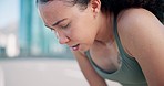 Fitness, breathe and tired woman in the city for race, marathon or competition training. Sports, rest and young female athlete runner sweating with fatigue on a break for cardio workout in town.