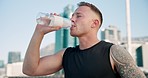 City, fitness and man drinking water, workout and exercise with wellness, tired and training with fatigue. Healthy person, athlete outdoor and runner with liquid, thirsty and exhausted with hydration