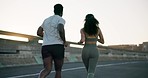 Couple, fitness and running on road for workout, outdoor exercise or training together in urban town. Rear view of active man and woman athlete or runners in sprint, cardio or sports marathon in city