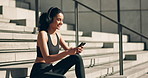 Headphones, woman and phone on steps for fitness, chat or text and listening to music before workout or exercise. Wellness, athlete and smartphone for training motivation, radio or audio for running