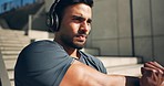 Man on steps for fitness, warm up and headphones for muscle workout on morning body training. Urban exercise, power and performance, athlete on stairs with music, stretching and healthy outdoor sport