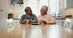 Senior people, laughing and bonding in kitchen with coffee, retirement and conversation in house. Happy couple, funny or joke together in home with biscuits, cookies or morning tea at breakfast table