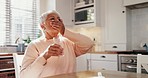 Old woman with pills in kitchen, health and drinking water, supplements for wellness or sick with daily routine at home. Retirement, treatment with medicine and healthcare, drugs and vitamins