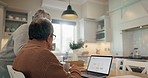 Senior, couple and coffee with laptop on kitchen table for online shopping, internet browsing and website search. Old people, tea and wireless mobile with technology, searching and talking at home

