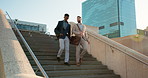 Business, men and walking on stairs outdoor in city for morning travel to work together with communication. Professional, people and moving down steps with conversation for commute and buildings