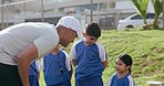 Coach, kids and team with fist bump, conversation and field for soccer, training and exercise for match, competition and workout. Sports, sportswear and players for discussion, outdoors and playing