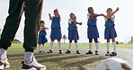 Children, stretching and sport on soccer field with coach for training and school fitness. Youth, kids and workout for competition in uniform with girl and athlete group with students and exercise