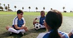 Children, ball and game on field while sitting in circle for training, exercise and fun outdoor in nature. Sports, kids and soccer player on grass with football and happiness for fitness and workout