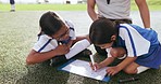 Strategy, clipboard and children on field for soccer prepare for game, match and practice outdoors. Sports, coaching and young kids writing for training schedule, exercise and planning for tournament