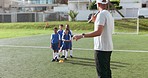 Soccer, kids and training for game and sport drill for workout and exercise on a school field. Students, coaching and children with teamwork, player and team together with youth and athlete group