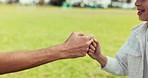 Fist bump, greeting of father and child for love, trust and solidarity outdoor at park. Hands together, closeup of dad and kid meeting for family support, healthy relationship or connection in nature