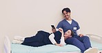 Healthcare, doctors or students on break with technology while resting on hospital bed, laugh and smile. Man, woman or friends by relaxing at work by reading on smartphone, social media or internet