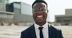 Happy, smile and face of African businessman in the city with good, confident and positive attitude. Happiness, ambition and portrait of young male corporate lawyer with glasses in an urban town.