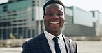 Confident, smile and face of professional black man in the city with good, happy and positive attitude. Happiness, ambition and portrait of young African male lawyer with glasses in an urban town.