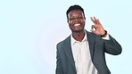 Face, hand pointing and business man with perfect sign in studio for checklist, info or sign up on blue background. Happy, portrait and African male entrepreneur show presentation, offer or success