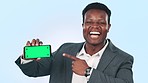 Pointing, business and black man with a smartphone, green screen and ok sign on a blue studio background. Portrait, African person and happy employee with a cellphone, tracking markers and promotion