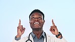 Face, doctor and black man with healthcare, pointing up and promotion on a blue studio background. Portrait, African person and medical professional with hand gesture, announcement and opportunity