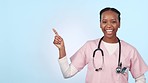 Happy black woman, doctor and pointing in advertising or marketing against a studio background. Portrait of African female person, healthcare or medical nurse smile showing deal or list on mockup