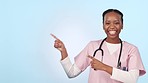 Happy black woman, doctor and pointing in marketing or advertising against a studio background. Portrait of African female person, healthcare or medical nurse smile showing deal or list on mockup