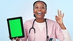 Green screen, tablet and woman doctor with perfect hands in studio for advice, news or info on blue background. Nurse, portrait and digital space with success emoji for healthcare, schedule or promo