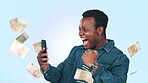 Phone, money rain and man or winner success, wow and winning lottery, online gambling or competition in studio. Cash in air, financial freedom and african person in yes and mobile on blue background
